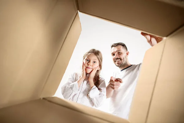 Pai com filha desembalando e abrindo caixa de papelão e olhando para dentro — Fotografia de Stock