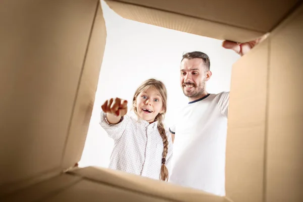 Pai com filha desembalando e abrindo caixa de papelão e olhando para dentro — Fotografia de Stock