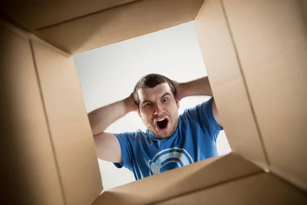 Homem desembalagem e caixa de papelão de abertura e olhando para dentro — Fotografia de Stock