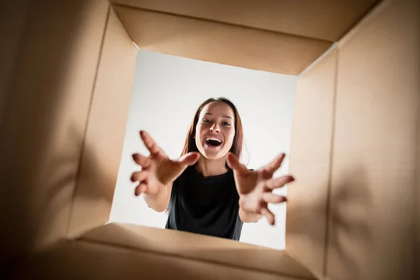 Vrouw uitpakken en openen van kartonnen doos en op zoek binnen — Stockfoto