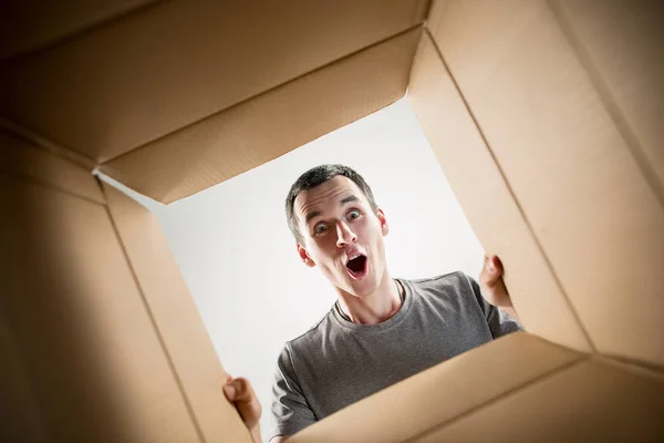 Homme déballer et ouvrir la boîte en carton et regarder à l'intérieur — Photo