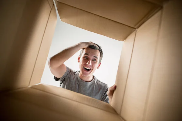 Hombre desembalaje y apertura caja de cartón y mirando dentro —  Fotos de Stock