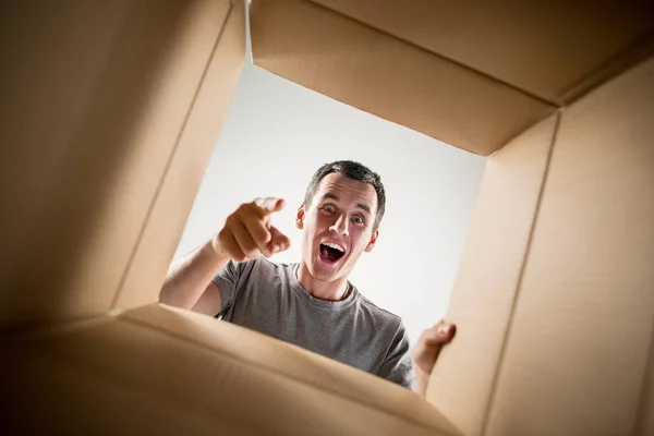 Hombre desembalaje y apertura caja de cartón y mirando dentro — Foto de Stock