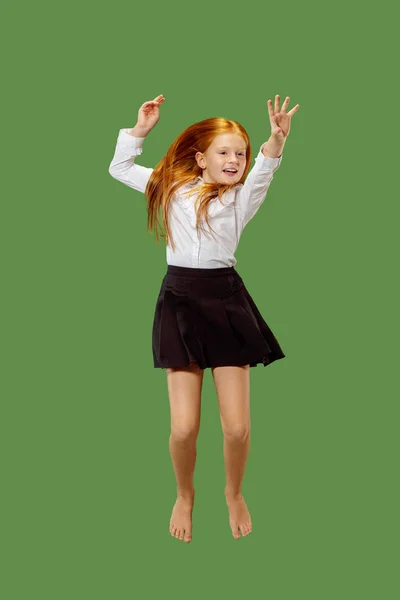 Jovem feliz caucasiano adolescente menina pulando no ar, isolado no fundo verde — Fotografia de Stock