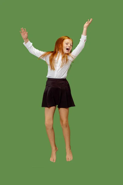 Gelukkig Kaukasische tiener meisje springen in de lucht, geïsoleerd op groene achtergrond — Stockfoto