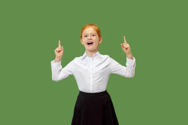 Das glückliche Teenager-Mädchen, das vor grünem Hintergrund steht und lächelt. — Stockfoto