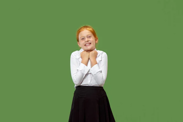 Den glada teen flicka står och ler mot grön bakgrund. — Stockfoto