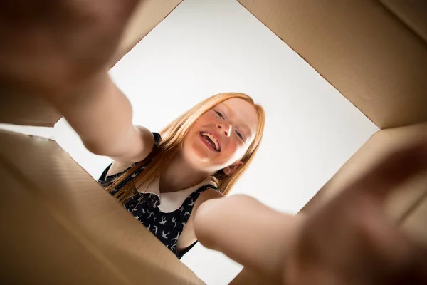 Flickan uppackning och öppna kartongen och titta inuti — Stockfoto
