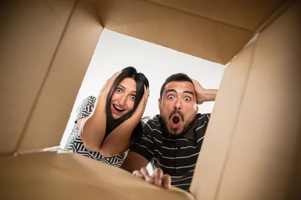 A pár kicsomagolás és kartondoboz megnyitása és keresnek belül — Stock Fotó