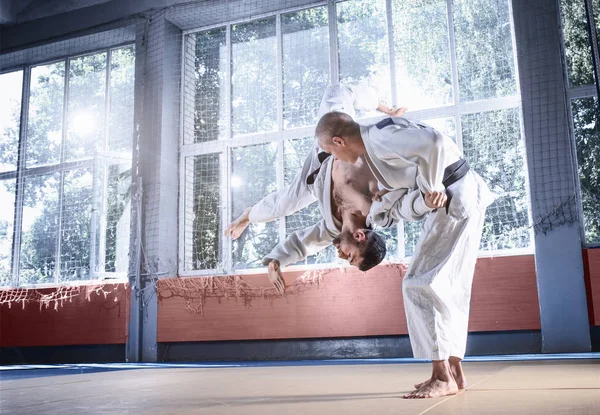 Dos luchadores de judo mostrando habilidad técnica mientras practican artes marciales en un club de lucha —  Fotos de Stock