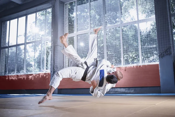 Dos luchadores de judo mostrando habilidad técnica mientras practican artes marciales en un club de lucha — Foto de Stock