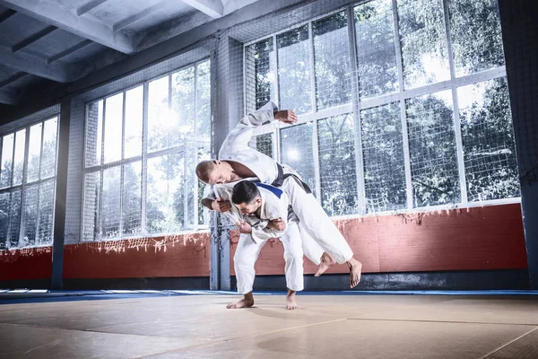 Dos luchadores de judo mostrando habilidad técnica mientras practican artes marciales en un club de lucha — Foto de Stock