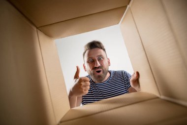 Açma ve karton kutusunu açıp içeri arayan adam