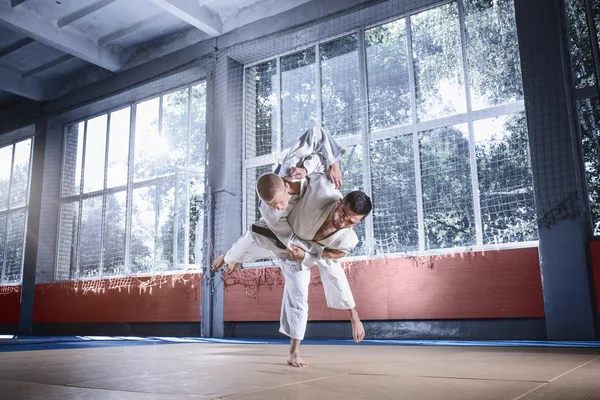 Dos luchadores de judo mostrando habilidad técnica mientras practican artes marciales en un club de lucha —  Fotos de Stock