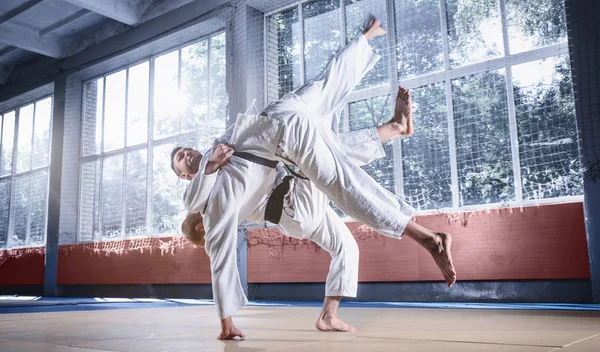 Two judo fighters showing technical skill while practicing martial arts in a fight club