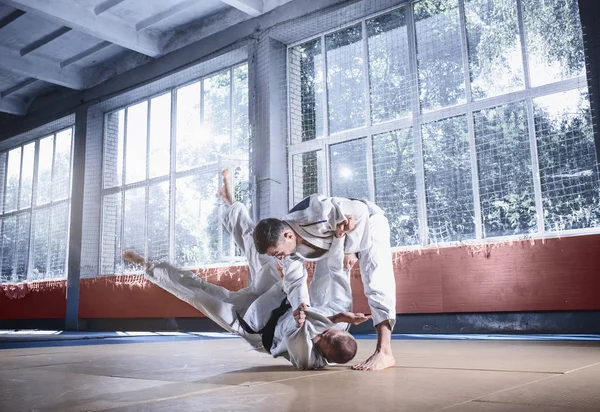 Two judo fighters showing technical skill while practicing martial arts in a fight club — Stock Photo, Image