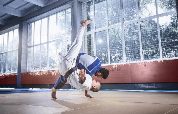 Två judo fighters visar teknisk skicklighet samtidigt öva kampsporter i en kamp klubb — Stockfoto
