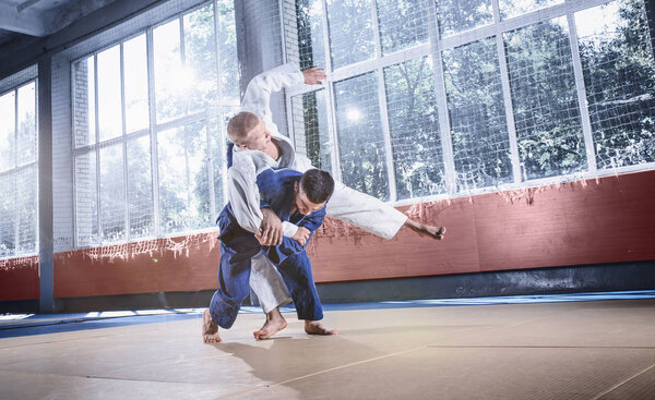 Two judo fighters showing technical skill while practicing martial arts in a fight club