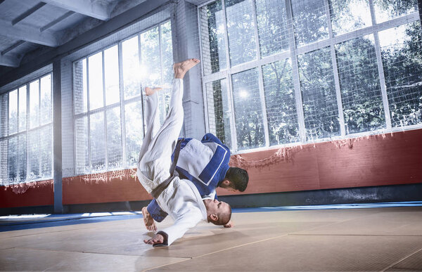 Two judo fighters showing technical skill while practicing martial arts in a fight club
