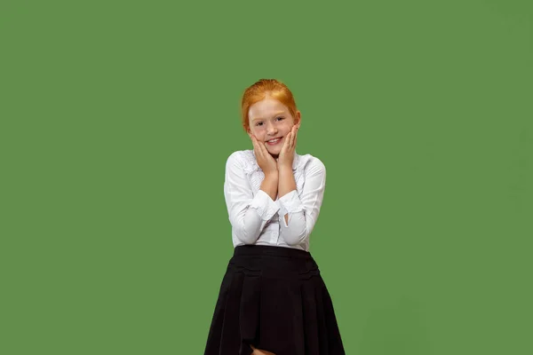 De gelukkige tiener meisje permanent en glimlachend tegen groene achtergrond. — Stockfoto