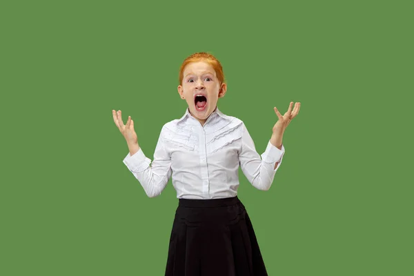 The young emotional angry teen girl screaming on green studio background — Stock Photo, Image