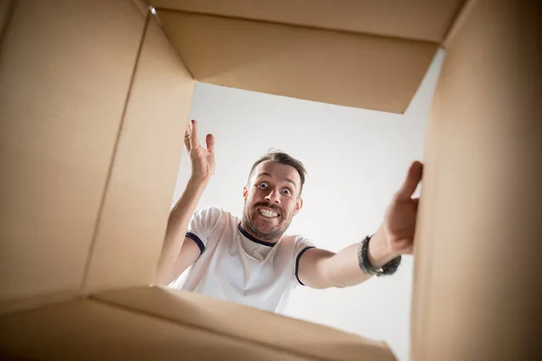 Hombre desembalaje y apertura caja de cartón y mirando dentro —  Fotos de Stock