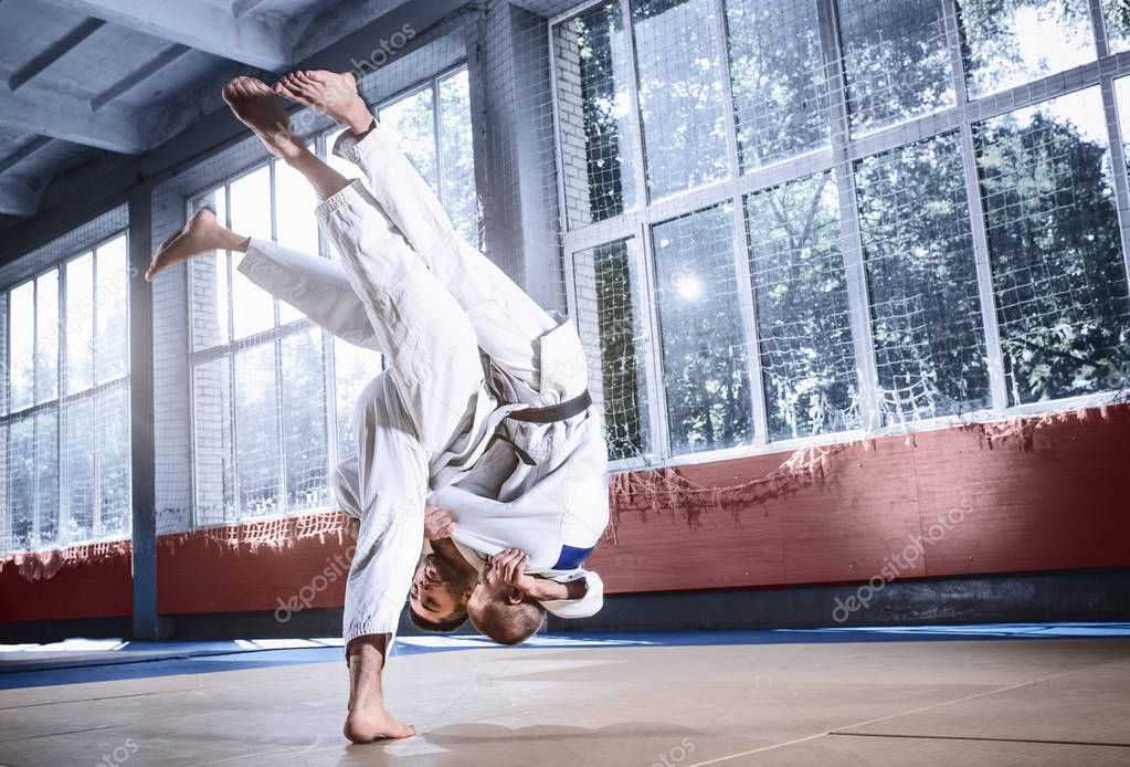 Two judo fighters showing technical skill while practicing martial arts in a fight club