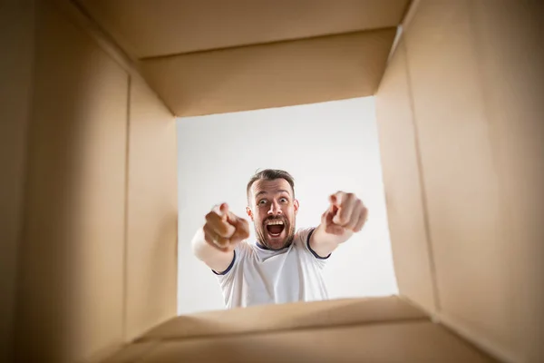 Homem desembalagem e caixa de papelão de abertura e olhando para dentro — Fotografia de Stock