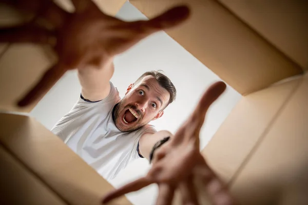 Hombre desembalaje y apertura caja de cartón y mirando dentro — Foto de Stock
