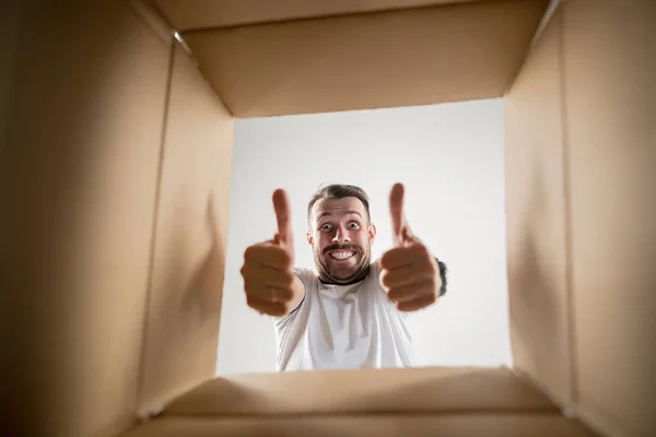 Homem desembalagem e caixa de papelão de abertura e olhando para dentro — Fotografia de Stock