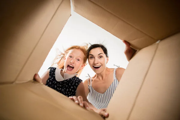 Anya és lánya, kicsomagolás és megnyitása karton doboz, és keres benne — Stock Fotó