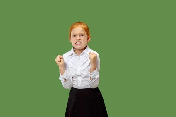 Portrait of angry teen girl on a green studio background — Stock Photo, Image