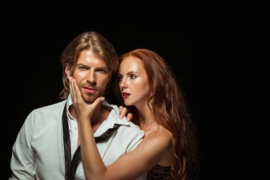 Gerçek tutku. Güzel genç çift bağ birbirlerine her iki duran siyah stüdyo duvara karşı sevgi dolu