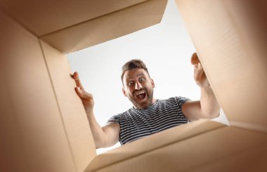 Açma ve karton kutusunu açıp içeri arayan adam