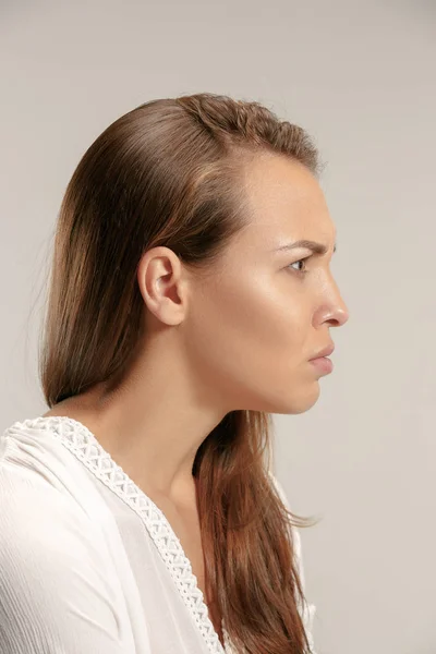 Retrato de uma mulher com raiva olhando para a câmera isolada em um fundo cinza — Fotografia de Stock