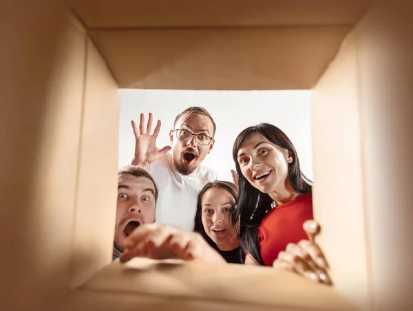 As pessoas desembalando e abrindo caixa de papelão e olhando para dentro — Fotografia de Stock