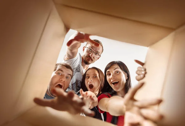 As pessoas desembalando e abrindo caixa de papelão e olhando para dentro — Fotografia de Stock