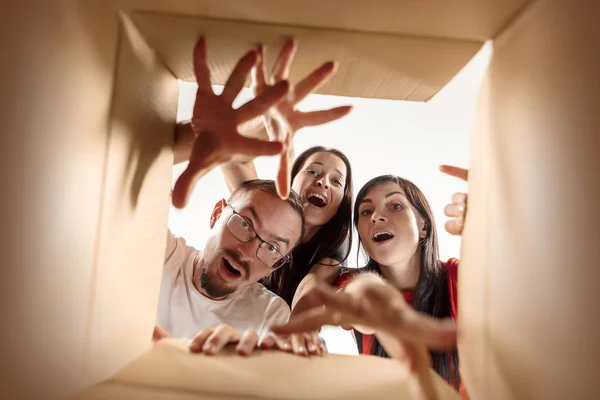 The people unpacking and opening carton box and looking inside — Stock Photo, Image