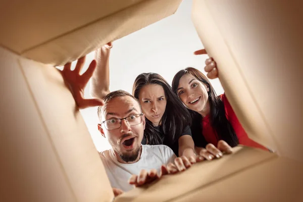 The people unpacking and opening carton box and looking inside — Stock Photo, Image