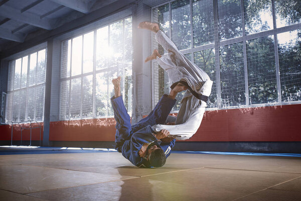 Two judo fighters showing technical skill while practicing martial arts in a fight club