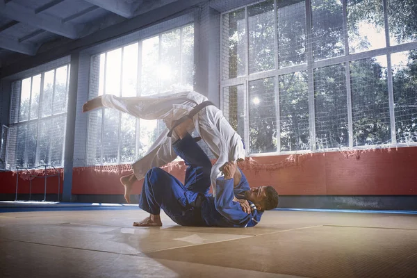 Två judo fighters visar teknisk skicklighet samtidigt öva kampsporter i en kamp klubb — Stockfoto