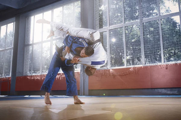 Dos luchadores de judo mostrando habilidad técnica mientras practican artes marciales en un club de lucha — Foto de Stock