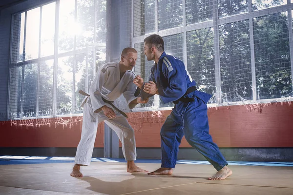 Dos luchadores de judo mostrando habilidad técnica mientras practican artes marciales en un club de lucha — Foto de Stock