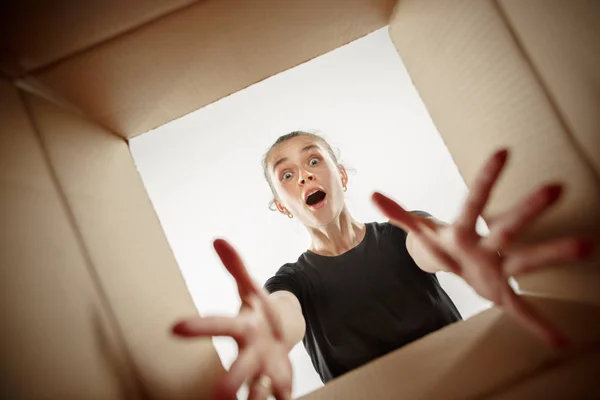Vrouw uitpakken en openen van kartonnen doos en op zoek binnen — Stockfoto