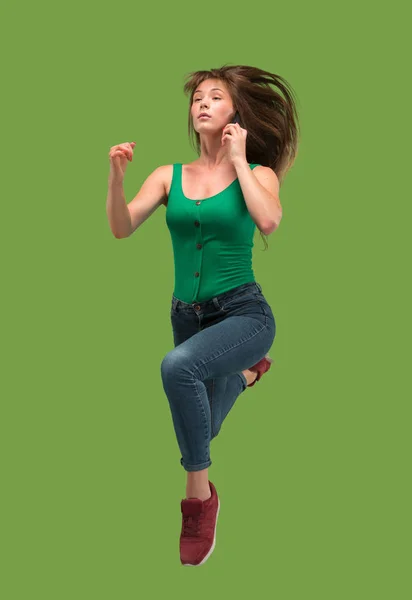Svoboda v pohybu. Hezká mladá žena skákání proti oranžové pozadí — Stock fotografie