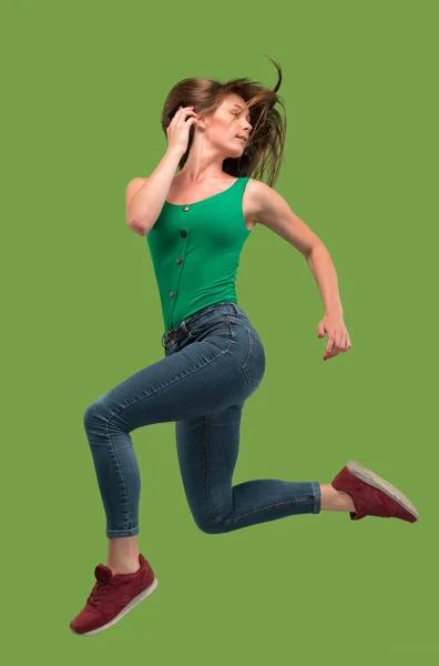 Libertad de movimiento. Mujer bastante joven saltando sobre fondo naranja — Foto de Stock