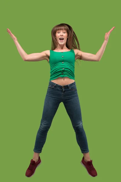 Freedom in moving. Pretty young woman jumping against orange background — Stock Photo, Image