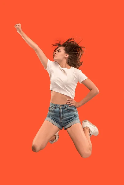 이동의 자유입니다. 오렌지 배경 점프 예쁜 젊은 여자 — 스톡 사진