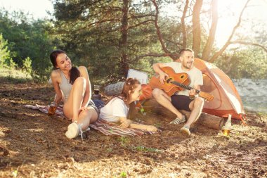Parti, orman, kadın ve erkek grubunun kamp. Onlar bir şarkı söylerken rahatlatıcı