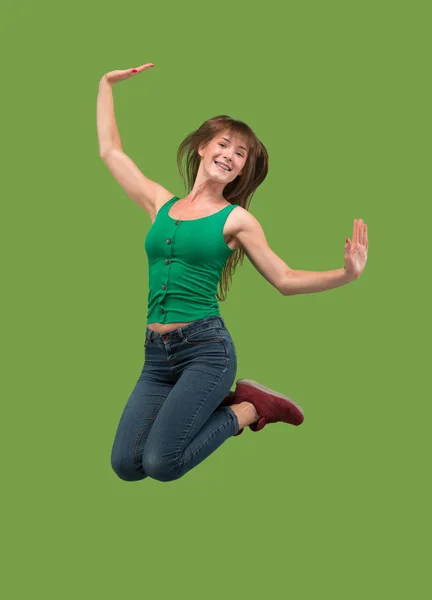 Vrijheid in beweging. Mooie jonge vrouw springen tegen oranje achtergrond — Stockfoto